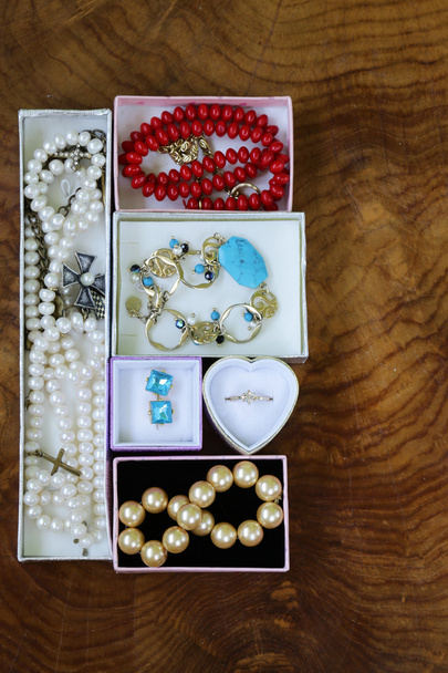 collane, anelli, orecchini, perle e oro in scatole su fondo di legno
 - Foto, immagini