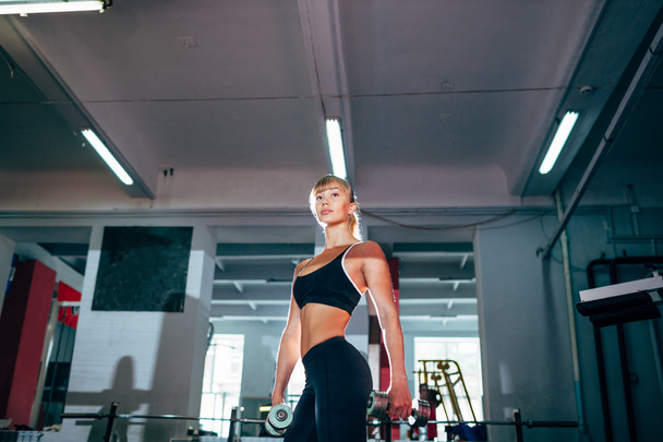 strong fitness woman holding dumbbells - Fotó, kép