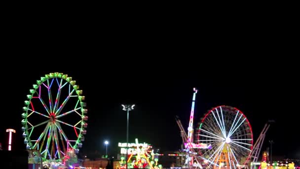 Amplia vista de una colorida feria de diversión por la noche
 - Metraje, vídeo