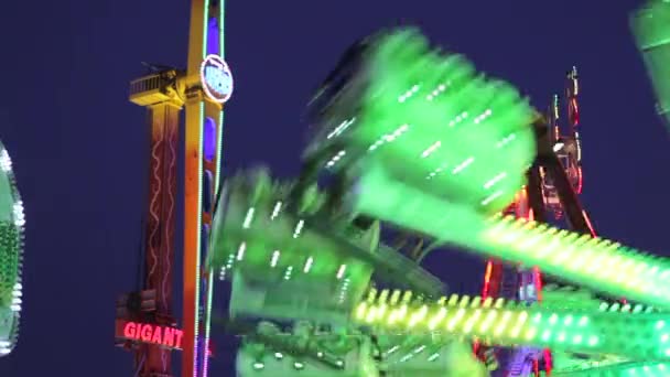 Attracties in beweging in de nacht in een amusement park - Video