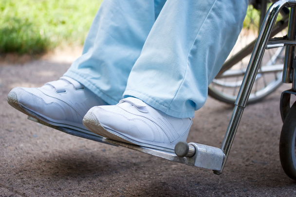 Benen en voeten van een vrouw in een rolstoel - Foto, afbeelding