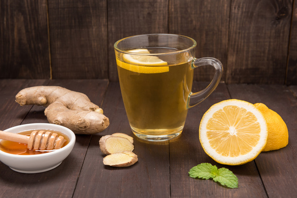Cup of ginger tea with lemon and honey on wooden background - Photo, image