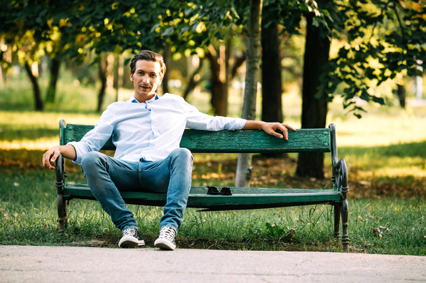 handsome adult man sitting on bench  - Valokuva, kuva