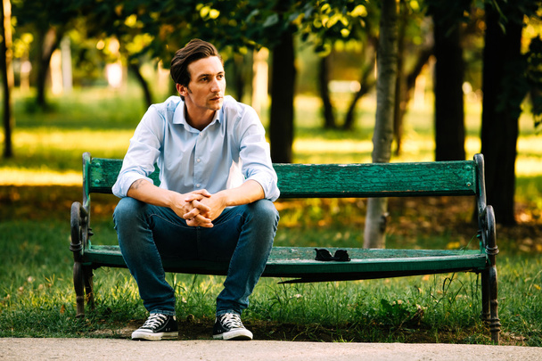handsome adult man sitting on bench  - Foto, Bild