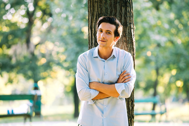 handsome adult man leaning on a tree - Foto, immagini