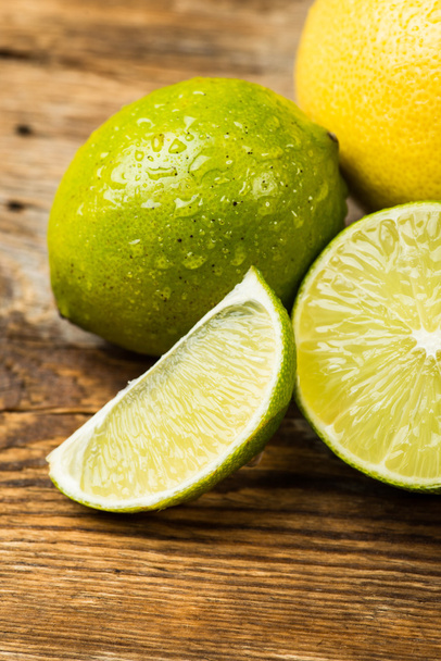 Citrons frais et juteux et citron vert sur une surface en bois
 - Photo, image