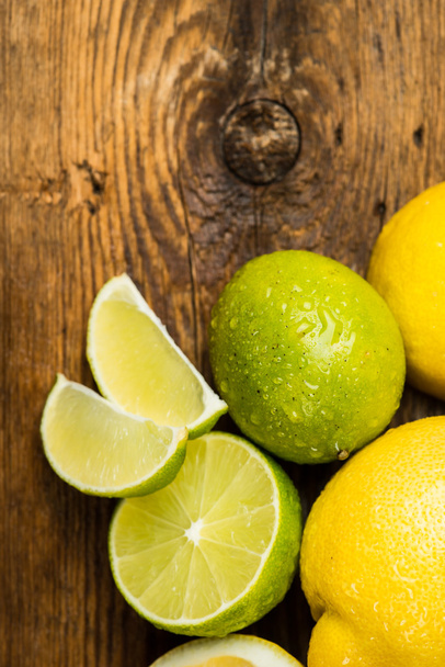 Fresh and juicy lemons and lime on a wooden surface - Фото, изображение