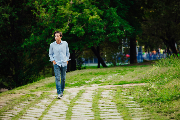 young adult walking alone in park - Fotó, kép