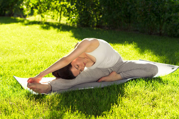 Молода жінка робить йогу в парку вранці
 - Фото, зображення