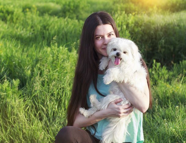 Morena bonita com um cachorro jovem desfrutando de um belo dia
 - Foto, Imagem