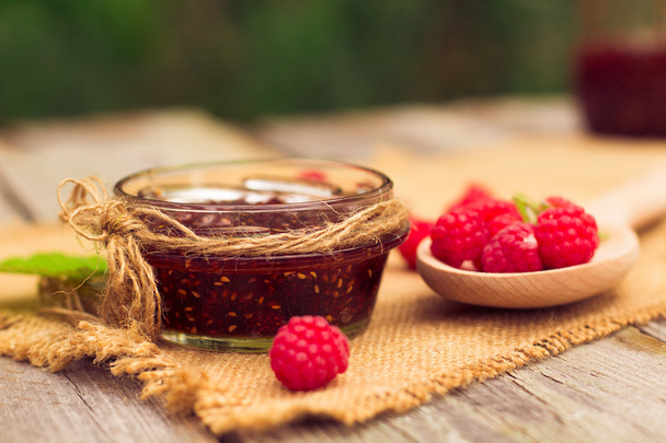 Fresh raspberries and jam on wooden table - Fotografie, Obrázek