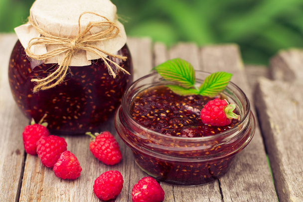 raspberry jam in a jar and fresh berries on the wooden table - Fotografie, Obrázek