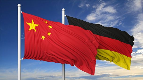 Waving flags of China and Germany on flagpole, on blue sky background. - Photo, Image