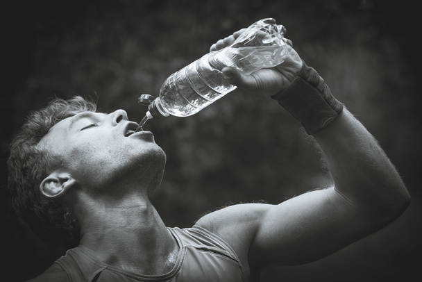 Man drinking water after running banks. Black and white photogra - Foto, immagini