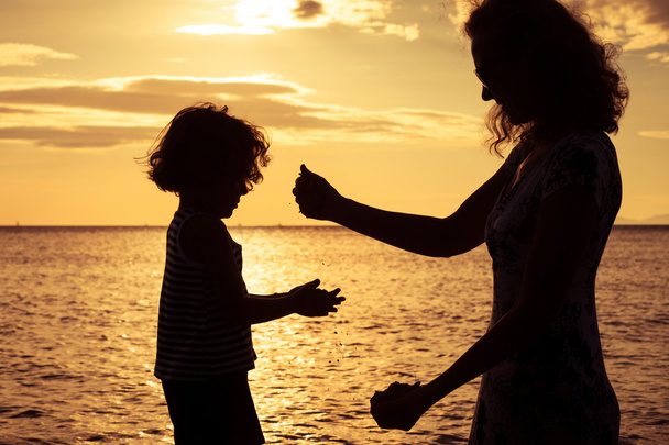 mãe e filho brincando na praia na hora do pôr do sol
. - Foto, Imagem