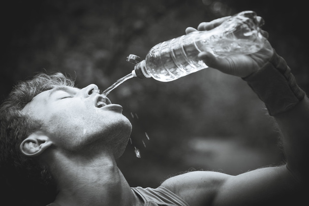 Man drinking water after running banks. Black and white photogra - Foto, immagini