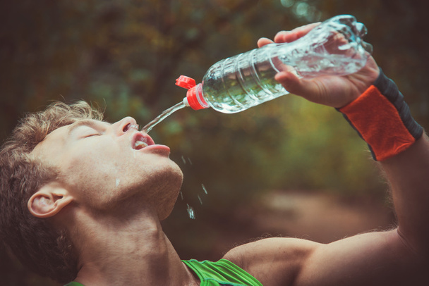 Man drinking water after running banks - Photo, image