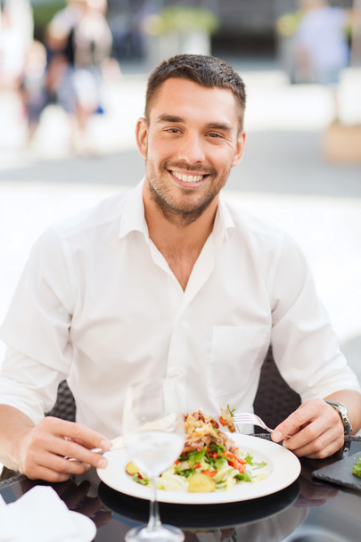 happy man eating salad for dinner at restaurant - Fotó, kép