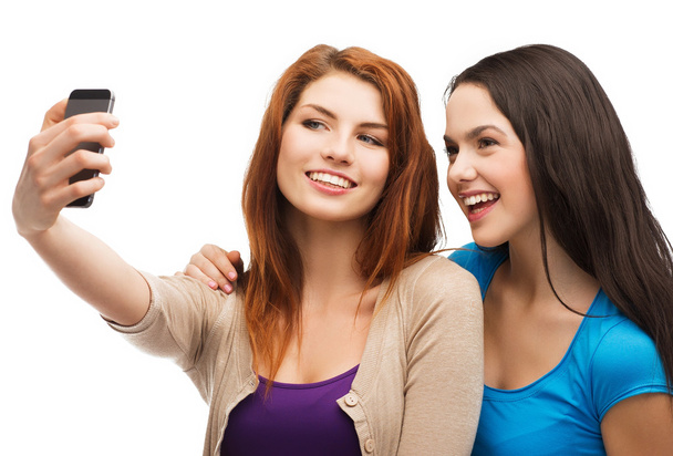 two smiling teenagers with smartphone - Foto, afbeelding