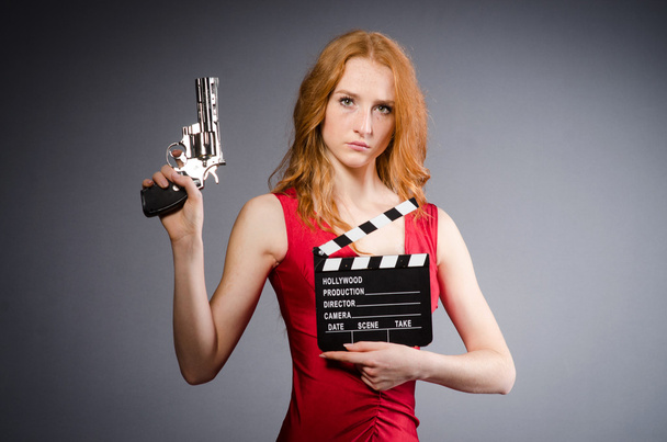 Girl with handgun and clapperboard - Photo, Image