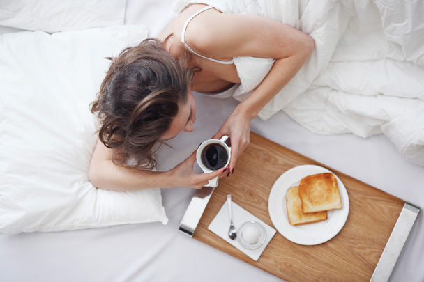 woman in bed eating breakfast - 写真・画像