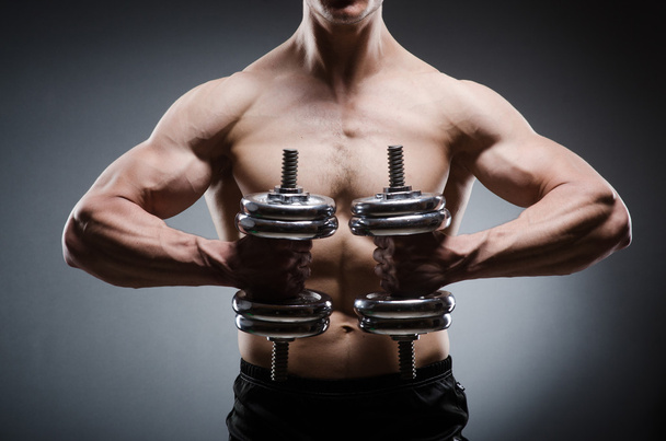 Muscular ripped bodybuilder with dumbbells - Photo, Image