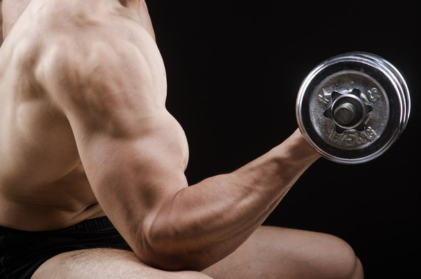 muskulöser zerrissener Bodybuilder mit Hanteln - Foto, Bild