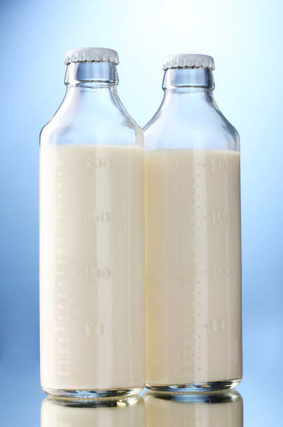 Bottles of milk on blue background - Photo, Image