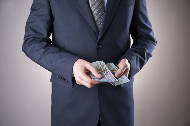 Businessman with money in studio. Corruption concept. Hundred dollar bills - Photo, Image