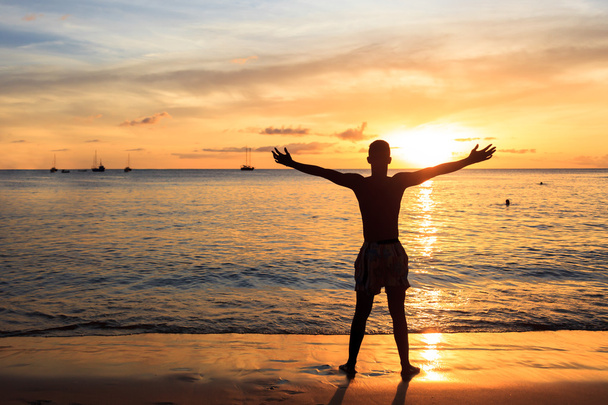 African  men raising arms up  at Sunset in Tarrafal beach in San - Fotografie, Obrázek
