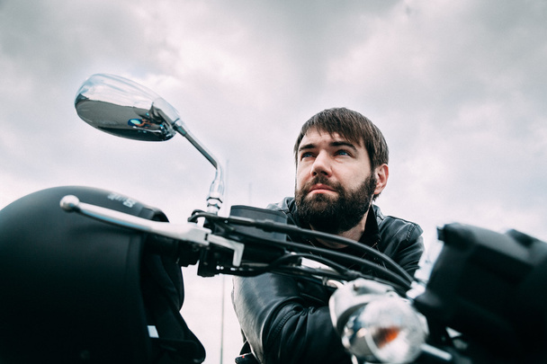 Байкер с бородой на мотоцикле в кожаной куртке
 - Фото, изображение