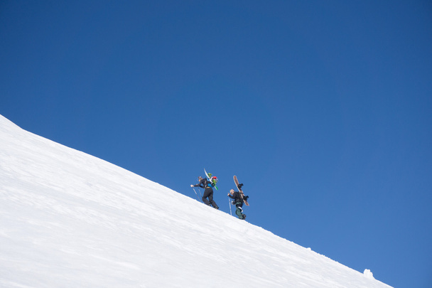 Snowboarders wandelen omhoog voor freeride - Foto, afbeelding