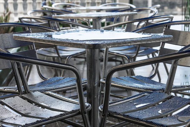 tables and chairs in rain - Fotografie, Obrázek