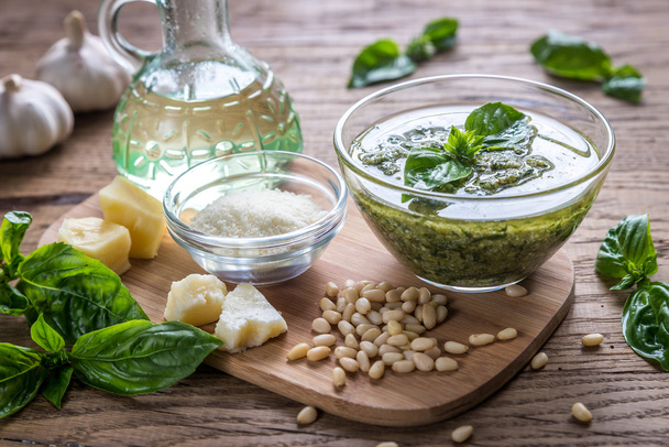 Pesto with ingredients on the wooden table - Foto, afbeelding