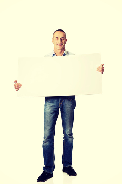 Handsome man holding an empty banner - Photo, Image