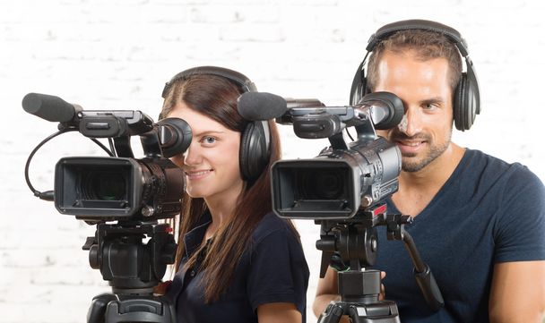 a man and a woman with professional video cameras - Photo, Image