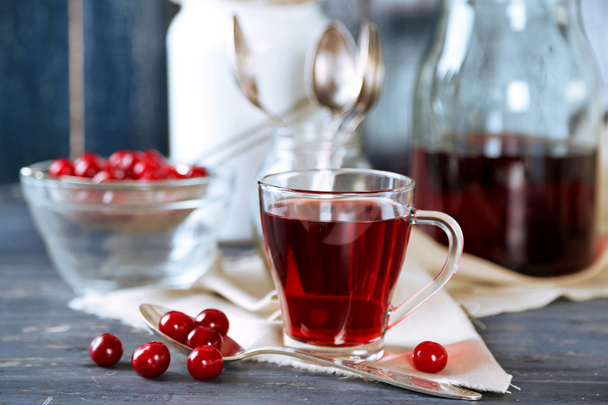 Sweet homemade cherry juice on table, on color wooden background - Foto, afbeelding