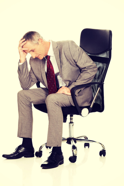 Stressed businessman sitting on armchair - Фото, изображение