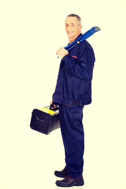 Mature worker with tools bag and wrench - Foto, Imagem
