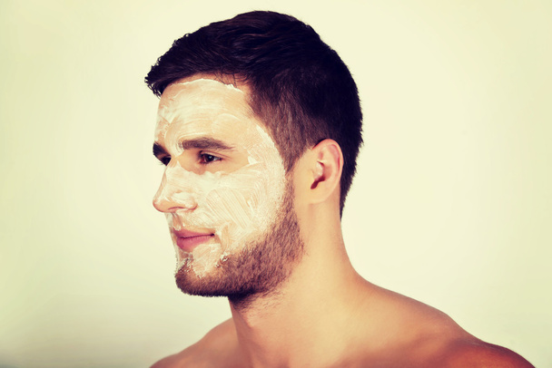 Man with cream moisturizer on his face. - Фото, зображення