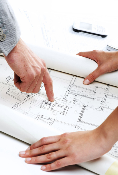 Architect’s hands pointing on the blueprint of new house project - Foto, afbeelding