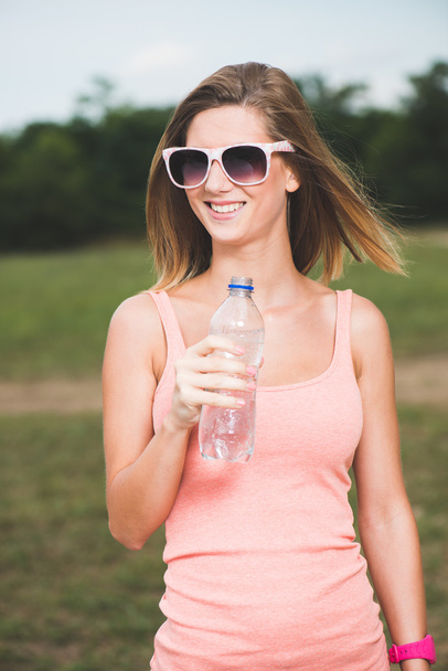 dorst fitness meisje houdt van fles water - Foto, afbeelding