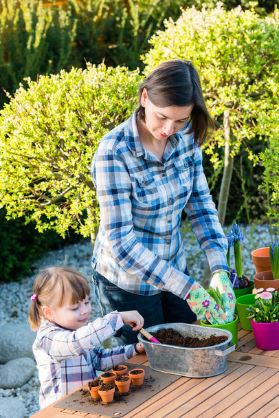 女の子は彼女の母親と一緒に花球根を植えること - 写真・画像