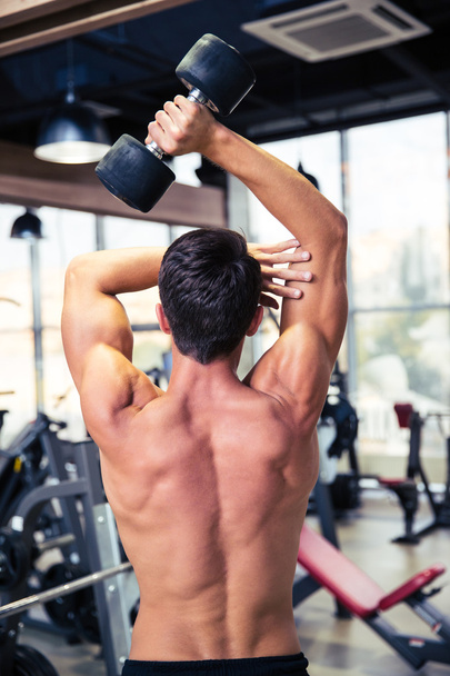 Man workout with dumbbell at gym - Valokuva, kuva