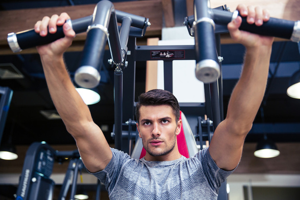 Man doing exercise on fitness machine in gym - Foto, immagini