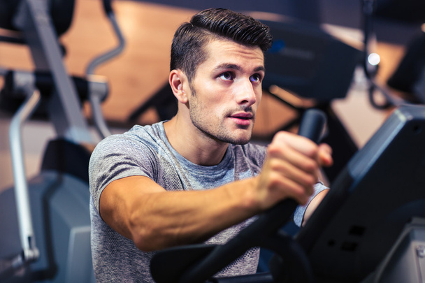 Man workout on a fitness machine at gym - Foto, afbeelding