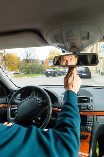 Motorista de táxi está olhando no espelho de condução
 - Foto, Imagem