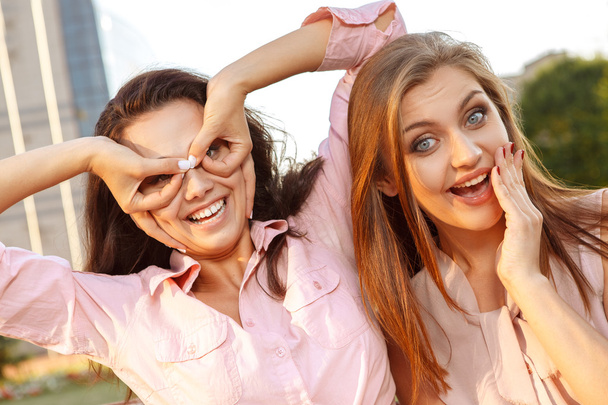 Two cheerful girls fooling around - Фото, изображение