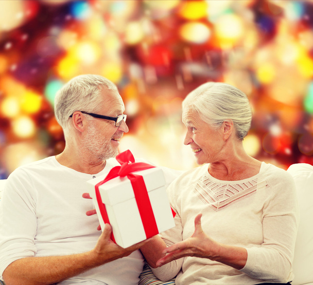 happy senior couple with gift box at home - Фото, зображення