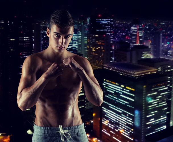 jonge man in gevechten of boksen positie - Foto, afbeelding